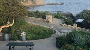 A coastal walkway with picnic tables, trash bins, and a stone wall. - LOVELY DESIGNER COTTAGE!   3 MIN WALK TO THE BEACH AND HEISLER PARK! (Laguna Beach)