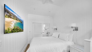A white-themed bedroom with a bed, bedside tables, and a wall-mounted lamp. - LOVELY DESIGNER COTTAGE!   3 MIN WALK TO THE BEACH AND HEISLER PARK! (Laguna Beach)