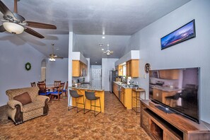 A compact living space with a kitchen, dining area, and a TV on the right.