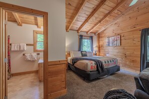 A wooden interior with a bed, a window, and a door. - Updated^Step-Free Access^EZMobility^KingSuite^2m to Parkwy^EZRoads^FastWiFi (Pigeon Forge)