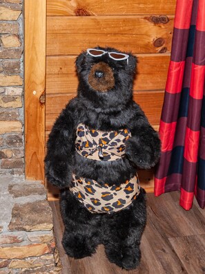 A bear statue wearing sunglasses and a leopard print vest, standing in front of a wooden wall with a stone base. - Updated^Step-Free Access^EZMobility^KingSuite^2m to Parkwy^EZRoads^FastWiFi (Pigeon Forge)