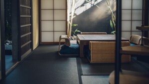 Perinteinen japanilainen huone, jossa on tatamimatto, matala pöytä ja punottu huonekalu.