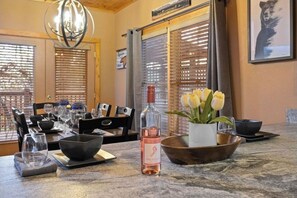 Enjoy a formal dining experience with a beautifully set table, complete with a wine bottle and fresh flowers.