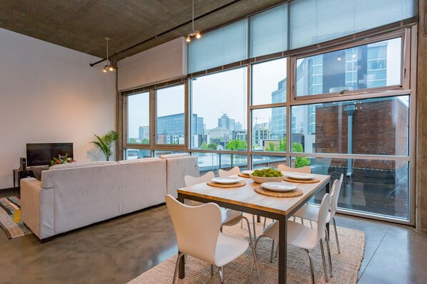 Enjoy the city view from this spacious living area with a comfortable sofa and flat-screen TV.