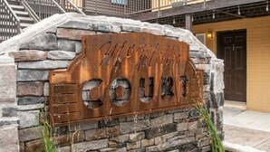 A rustic stone wall with a metal sign reading "McMillin Court." - 2BR Home Base Near Downtown Nashville (Nashville)