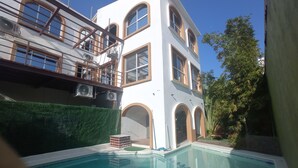 Un edificio de dos pisos con una piscina al frente.