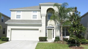 A two-story house with a garage, a large arched window, and a well-maintained lawn. - 5 Star Villa with Private Pool on Windsor Hills Resort, Orlando Villa 4862 (Orlando)