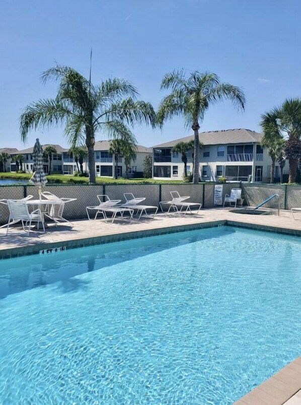 Relax by the resort's pool surrounded by comfortable lounge chairs and shaded areas.