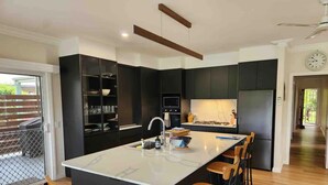 Una cucina moderna con un'isola centrale, sgabelli da bar e un'area pranzo.