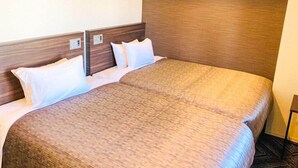 Ein Hotelzimmer mit einem großen Bett, einem Holzkopfbrett und weißer Bettwäsche.