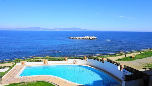 Una piscina con vistas al mar y a las montañas.