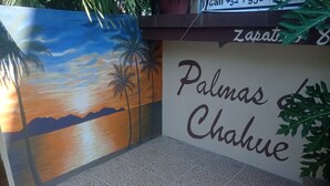 A wall with a palm tree mural and the text "Palmas Chahue". - PALMAS DE CHAHUE C (581 SF) (Crucecita)