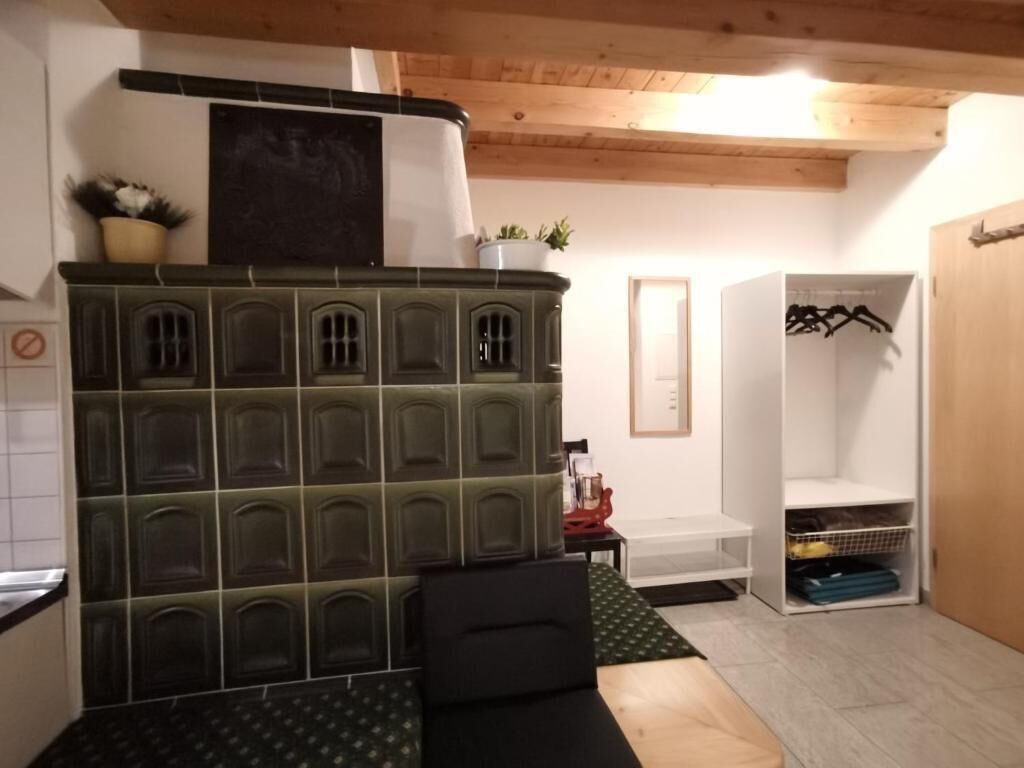A room with a built-in seating area, a white closet with hanging space, and a wooden ceiling.