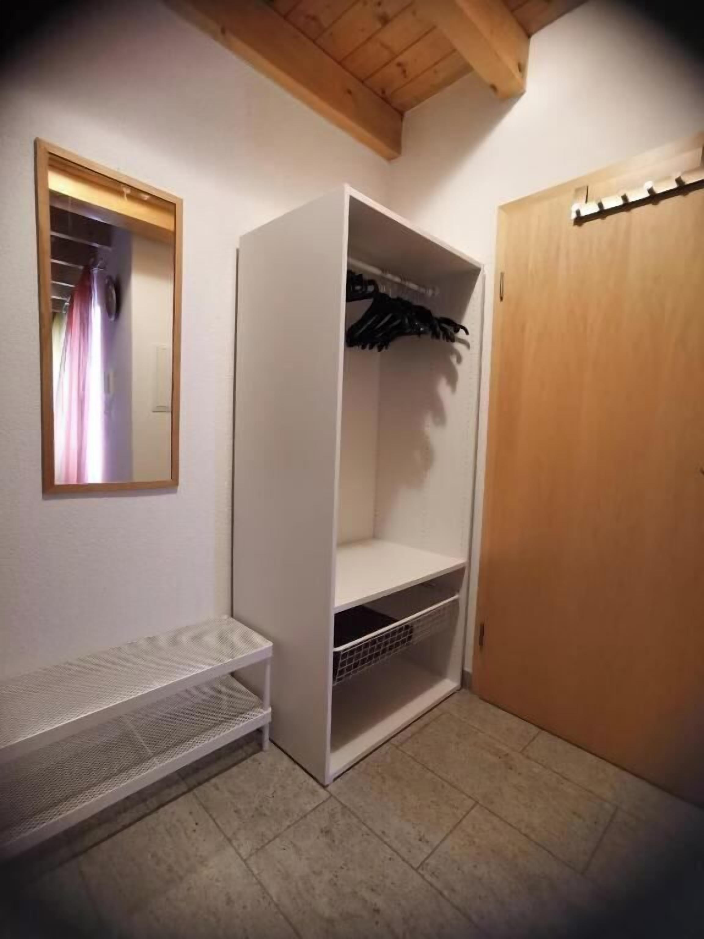 Une pièce avec une armoire, un miroir et une porte en bois.