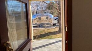 Vista a través de una puerta que da a un garaje con una caravana estacionada afuera.