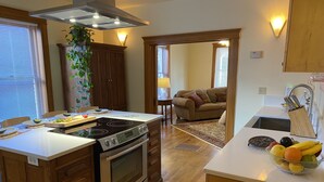 Una cocina con una isla central, armarios de madera, estufa y pileta.