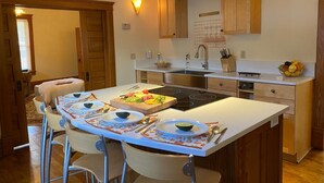 Una cocina moderna con una isla central, armarios de madera y estufa empotrada.