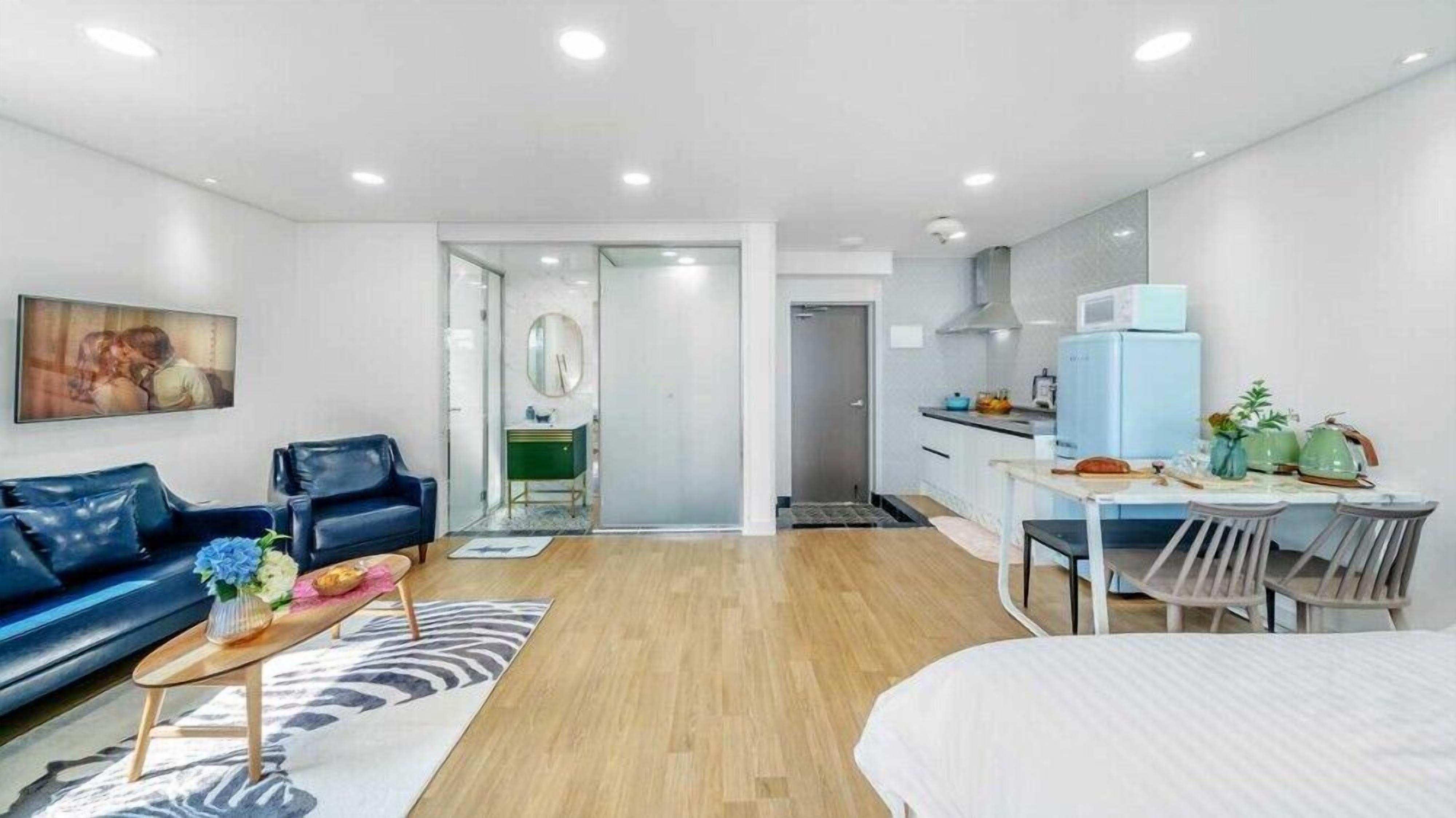 A modern apartment with a living room, a dining area, and a kitchen.