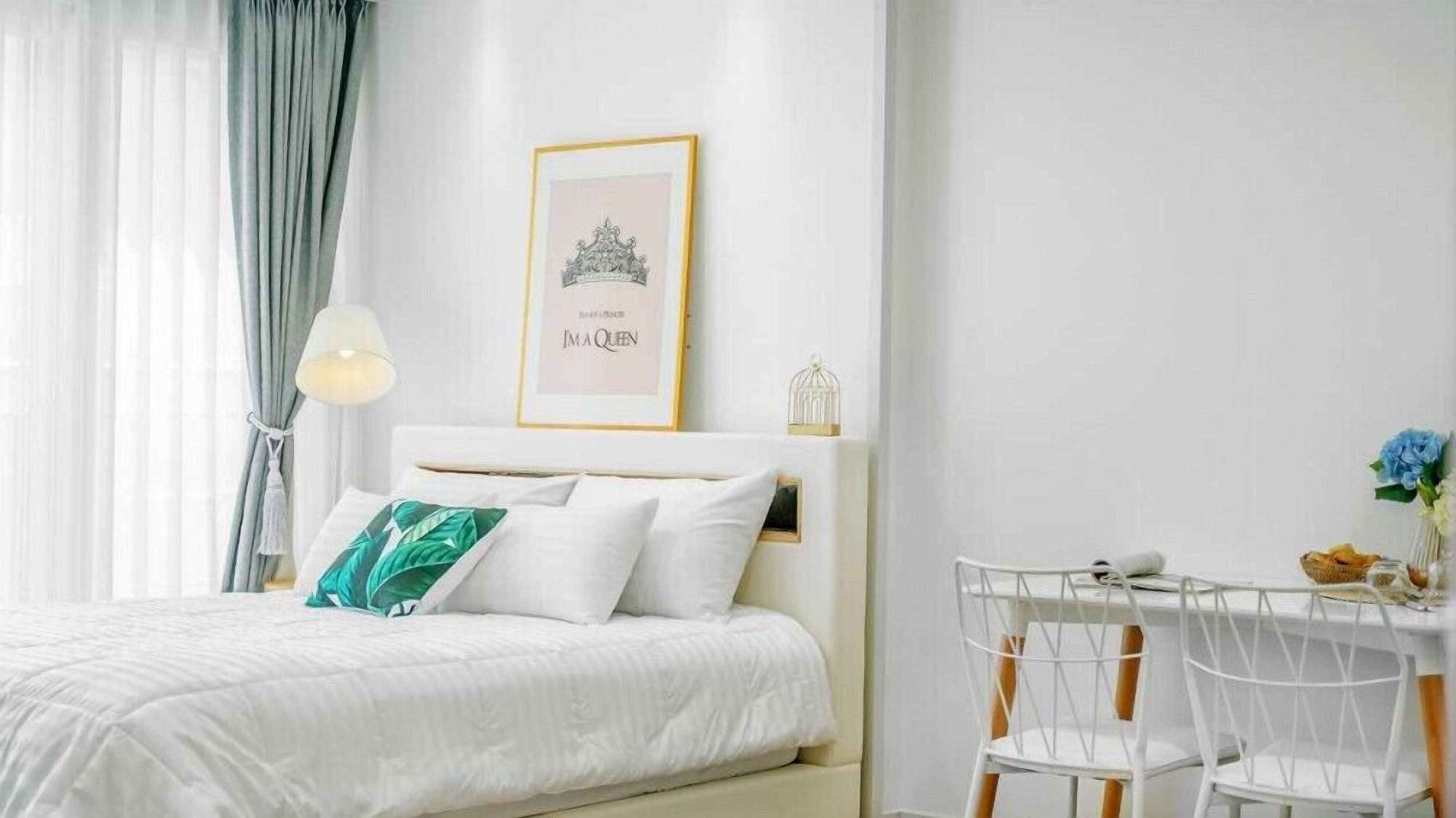 A neatly arranged bedroom with a bed, a bedside table, and a chair.