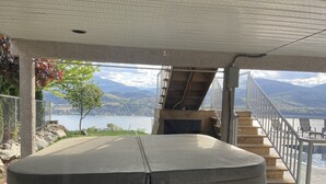 A hot tub under a covered area with a view of a lake and mountains. - Lake view with pool (Okanagan Falls)