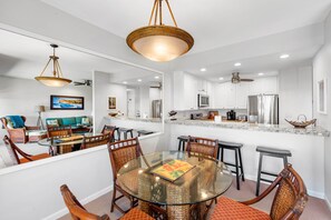A modern kitchen with white cabinets, stainless steel appliances, and a central island. - Poipu Sands 434, 2BD Ocean View, A/C, High End Vacation Rental (Koloa)