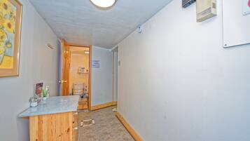 En gang med en receptionsdisk, en dør til et badeværelse og en vægmonteret klimaanlæg.