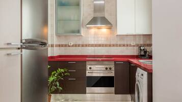 A modern kitchen with a stainless steel refrigerator, double oven, and built-in washing machine.