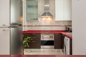 A modern kitchen with a stainless steel refrigerator, double oven, and built-in washing machine.