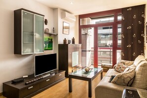 A living room with a TV, cabinet, sofa, and a glass table. - Vacation Apartment "Aurora Beach" with Wi-Fi & City View (Las Palmas de Gran Canaria)