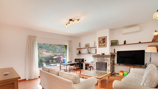 A living room with a sofa, a coffee table, a TV, and a fireplace. - Villa "La Alpispa" in the countryside with Pool, Wi-Fi, Terrace & Garden (Los Hoyos)