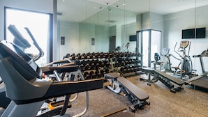 A modern gym with treadmills, dumbbells, and weight benches.
