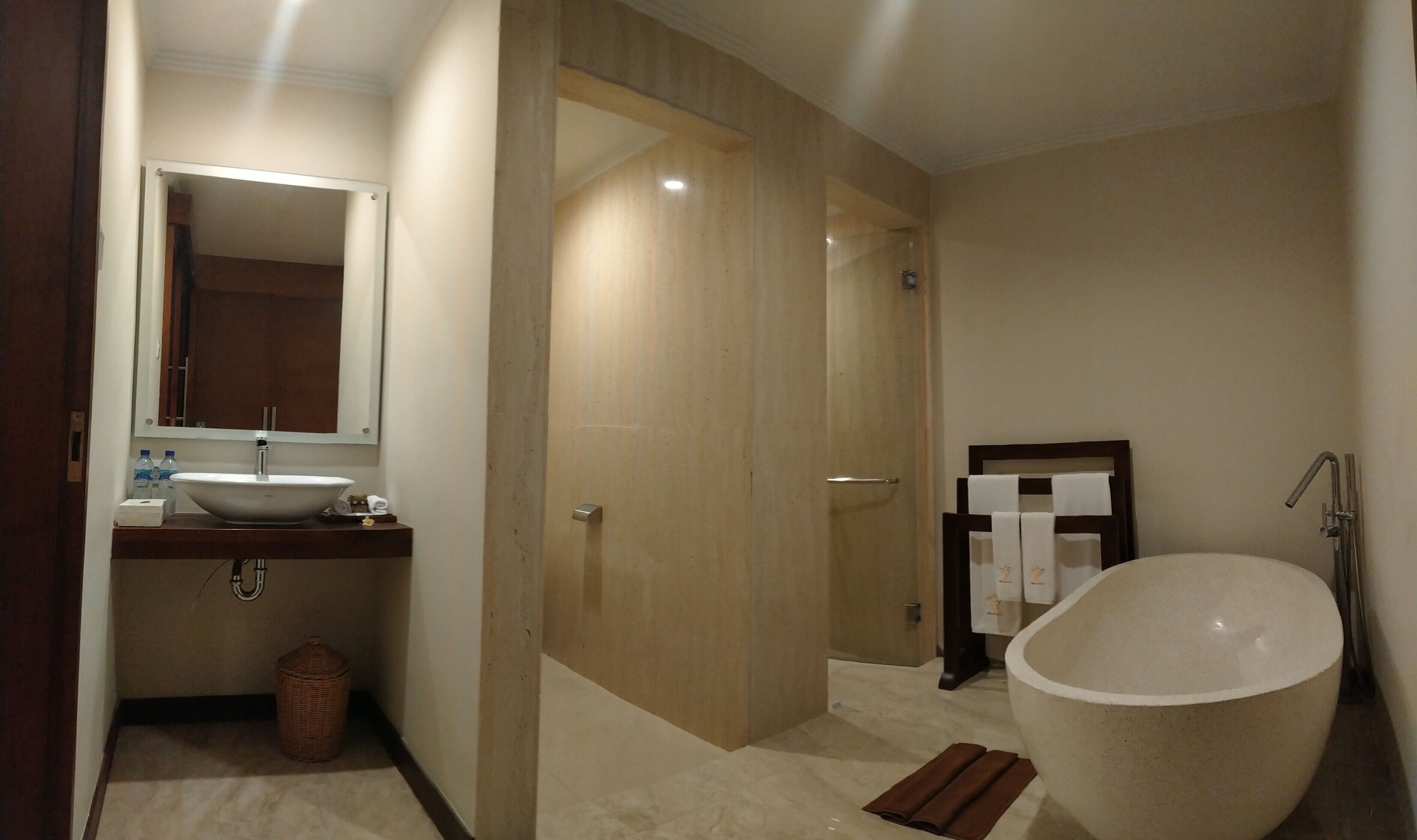Un baño moderno con una bañera independiente, un lavabo con espejo y una zona de ducha.