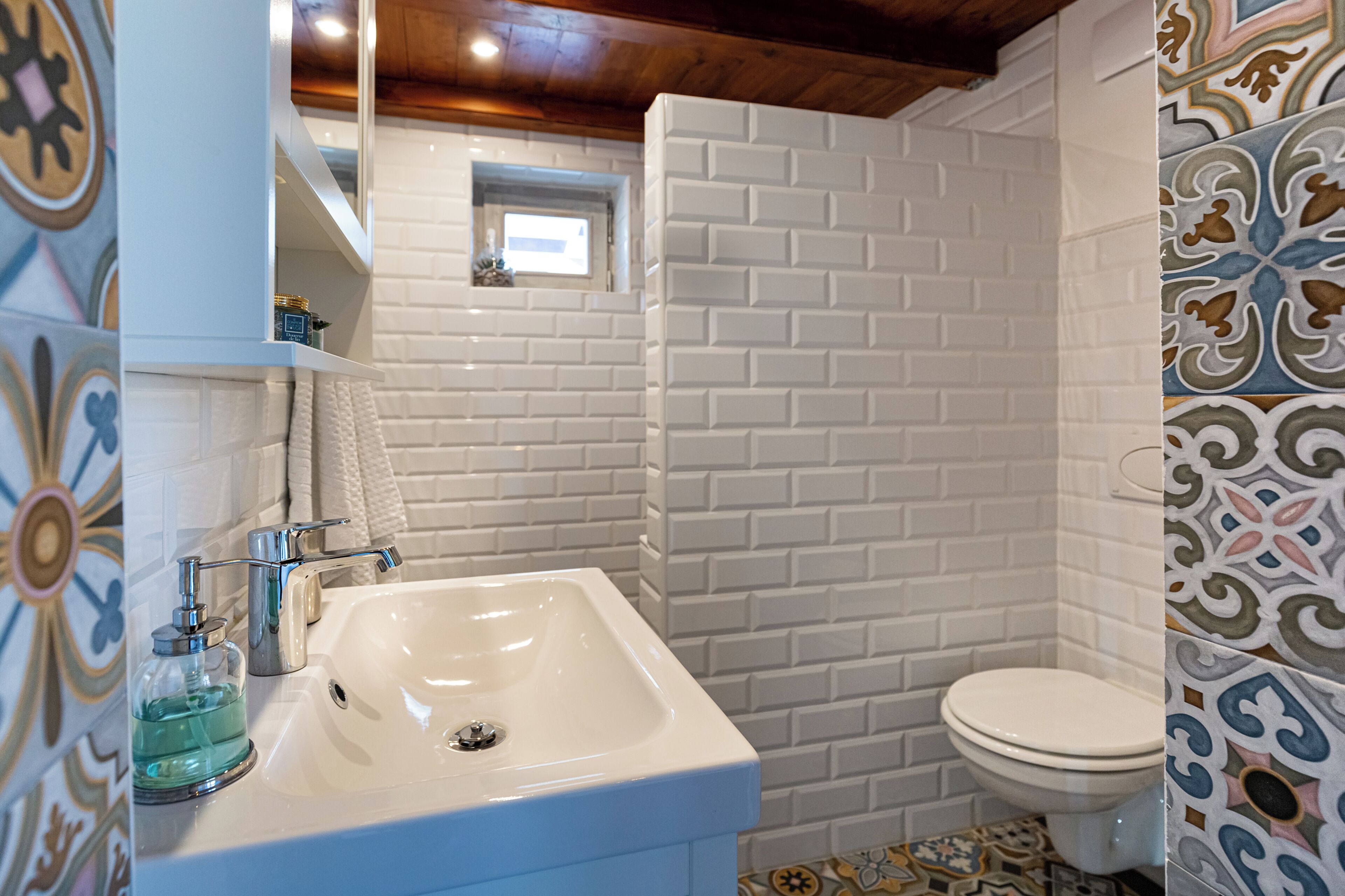 Une salle de bain avec un lavabo blanc, des toilettes et un espace douche.