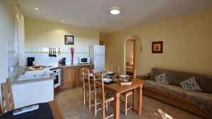A compact living space with a kitchen, dining area, and a sofa.