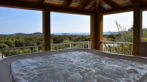 A hot tub with a view of a forest and the sea. - Villa 1 Chambre (2 - 4 Personnes) (Sainte-Lucie de Porto-Vecchio)