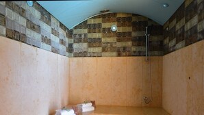 A bathroom with a tiled shower wall, a bathtub, and a towel rack with towels. - Villa 2 Chambres (4 - 6 Personnes) (Sainte-Lucie de Porto-Vecchio)