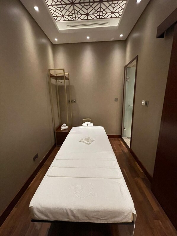 Une chambre d’hôtel avec un lit, une petite table et un miroir.