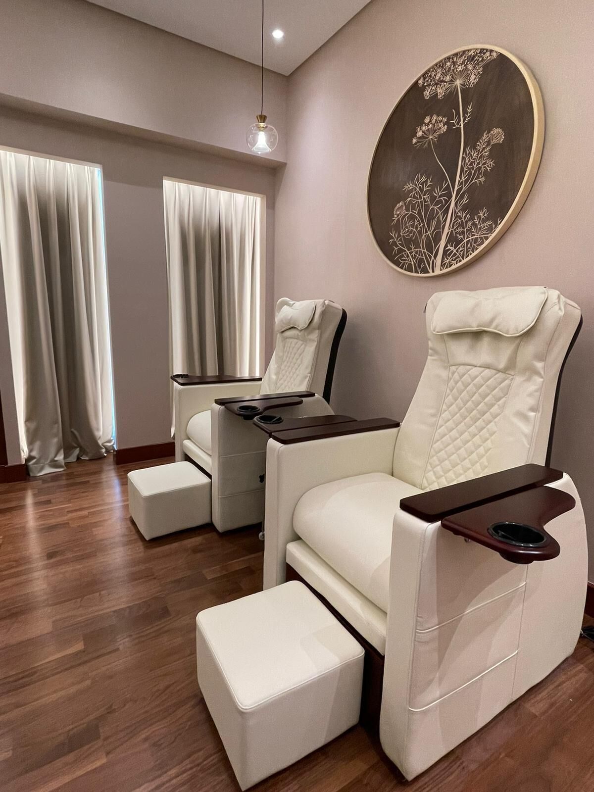 A room with two reclining chairs, a wooden floor, and a wall-mounted artwork.