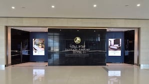 The exterior of the Bahrain Airport Hotel with a modern facade, large glass windows, and a prominent logo. - Bahrain Airport Hotel Airside Hotel for Transiting and Departing Passengers only (Muharraq)