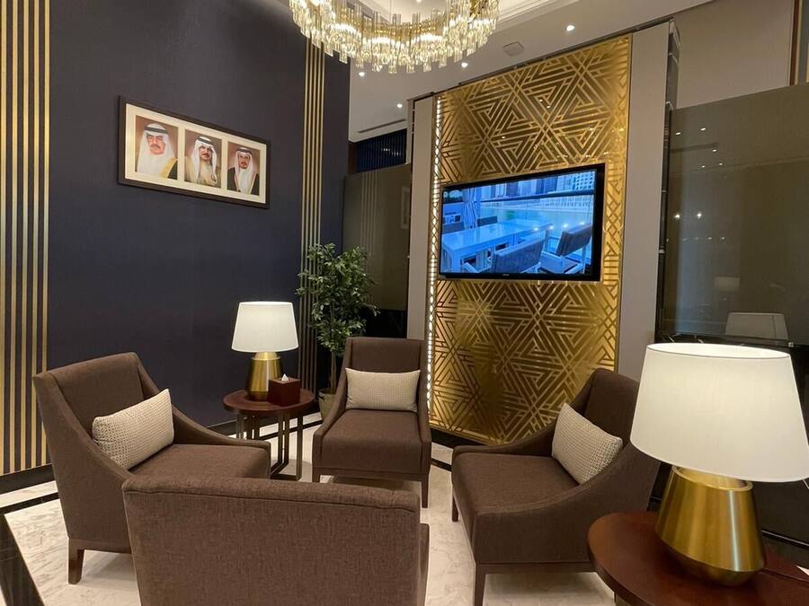 Una sala de estar moderna con una lámpara de araña grande, un televisor de pantalla plana y un muro con diseño.