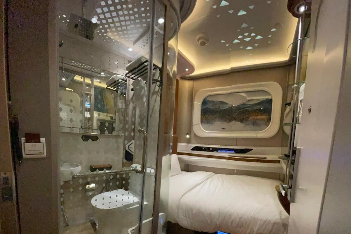 Un bagno compatto e moderno con box doccia in vetro, un water e un lavandino.