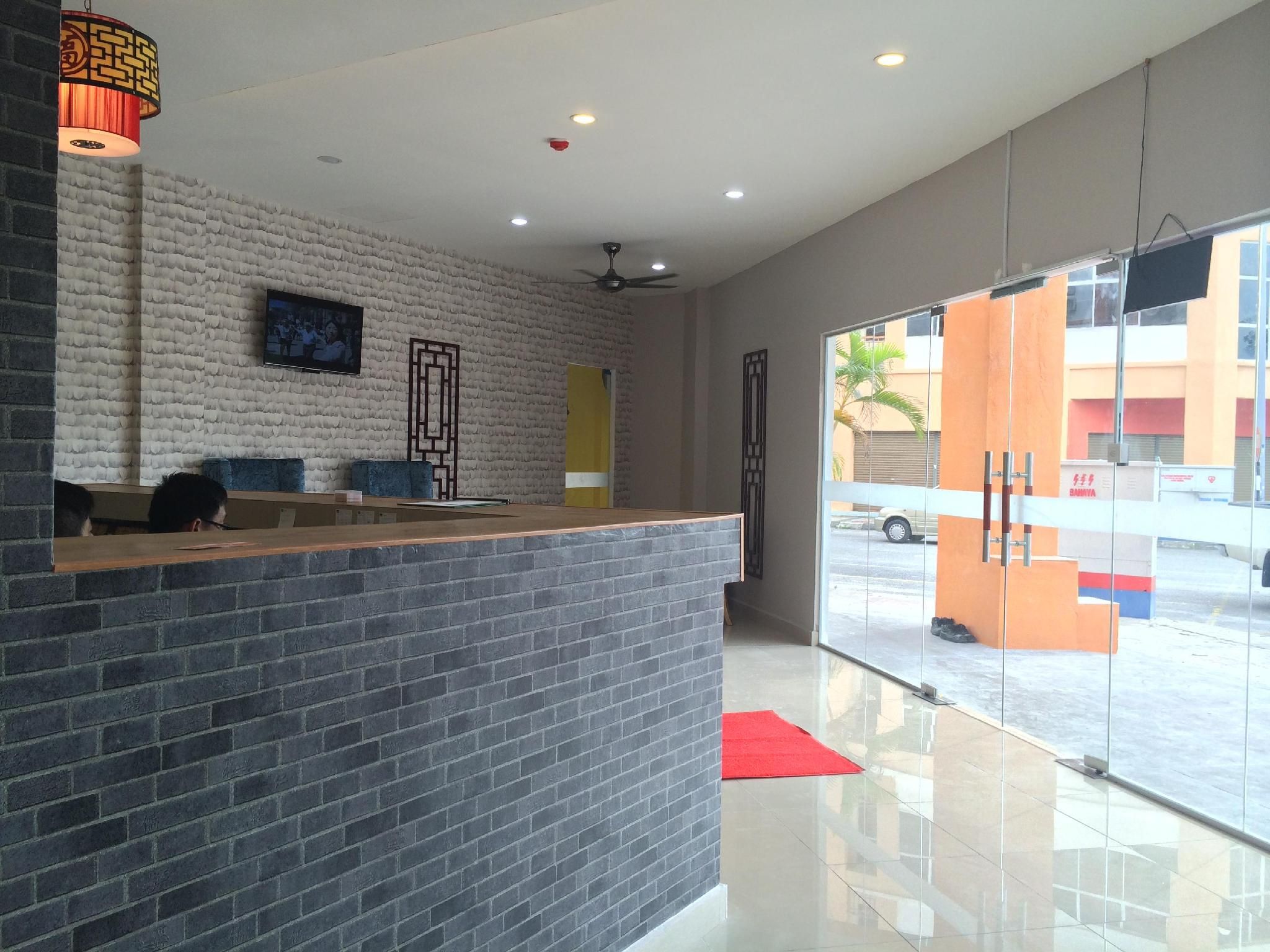 A reception area with a brick counter, a ceiling fan, and a large window offering a view of the street.