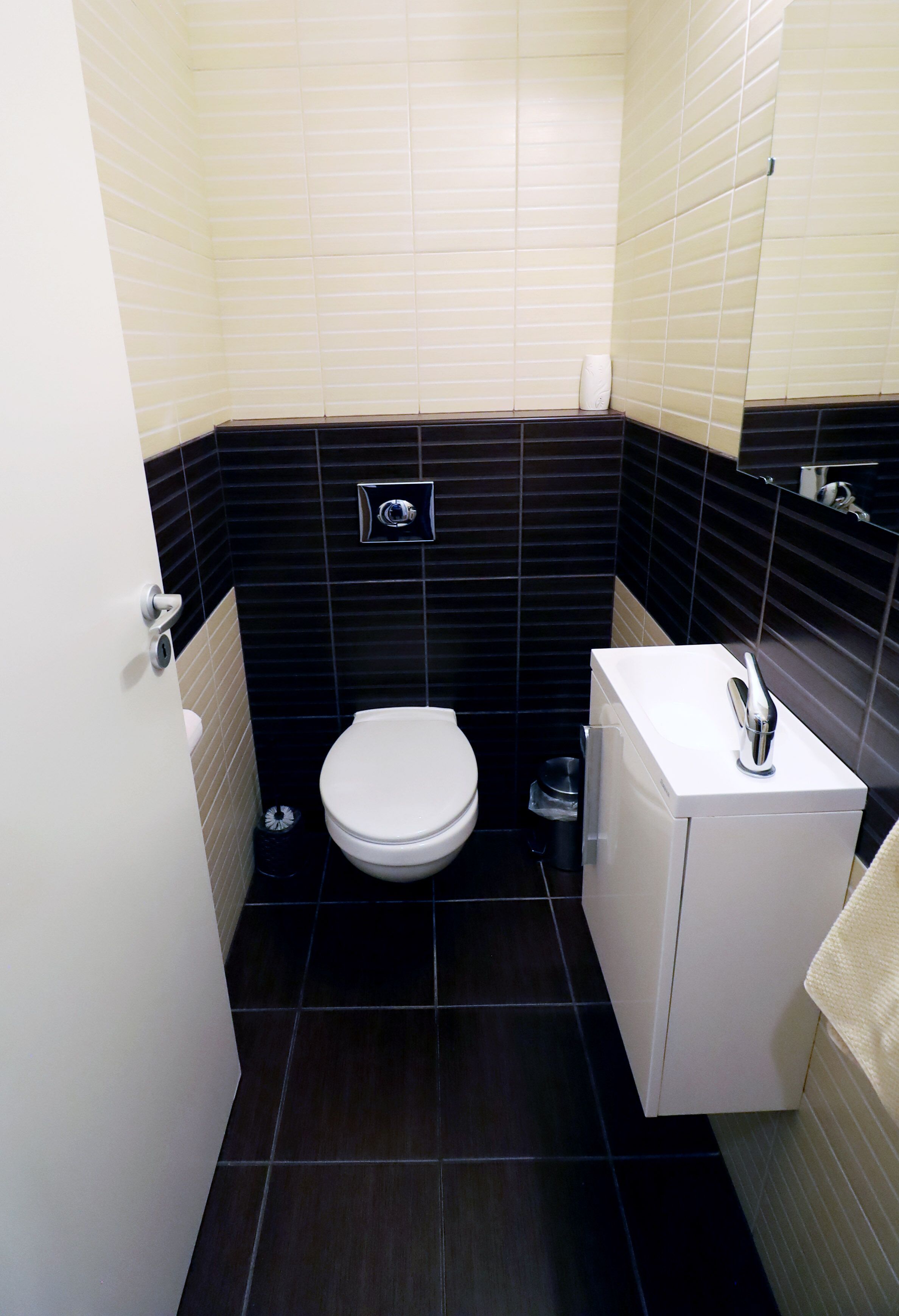Une petite salle de bain avec des toilettes, un lavabo et un miroir.