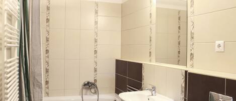 Un baño con bañera, lavabo y espejo.