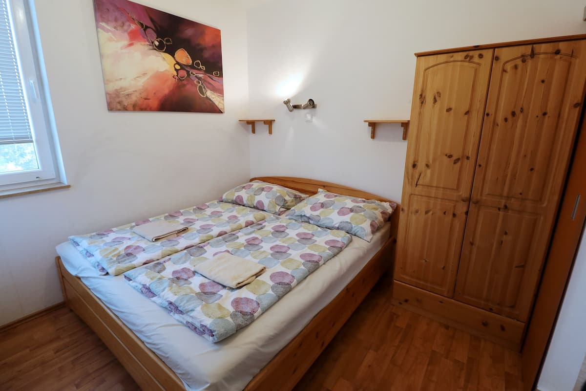 Ein Einzelbett mit Blumenmusterdecke, ein Holzschrank und ein Bild an der Wand.