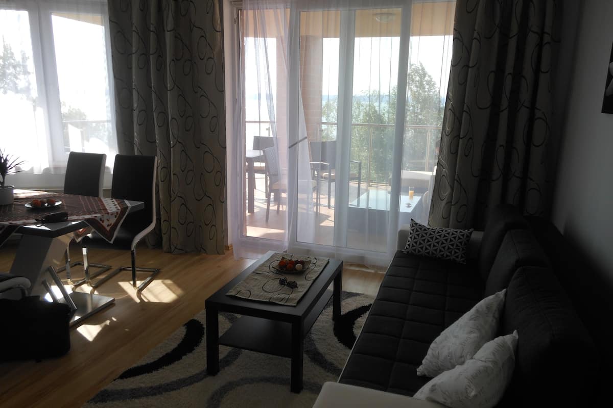 Ein Wohnzimmer mit einer Couch, einem Couchtisch und einem Essbereich mit Stühlen und einem Tisch.