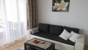 A living room with a sofa, a coffee table, and a wall-mounted picture.