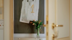 Une porte sur laquelle est fixé un tableau blanc affichant le chiffre 1, un vase de tulipes et une poignée de porte.