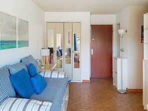 Ein Zimmer mit einem Bett, einem Spiegel, einer Tür und einer Stehlampe.