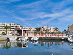 A marina with boats docked, a building labeled 'PORT DE BORMES,' and palm trees.